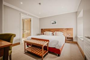 a bedroom with a large bed with a wooden headboard at Slebech Park Estate in Wiston