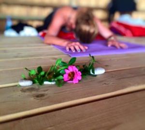 a woman is doing yoga on a purple mat with flowers at Melinda Pension & Restaurant in Mesudiye