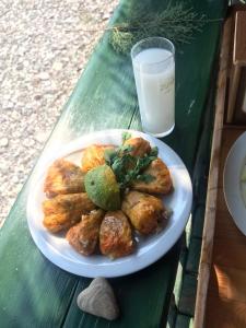 a plate of food on a table with a glass of milk at Melinda Pension & Restaurant in Mesudiye