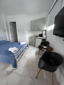 a bedroom with a bed and a table and a kitchen at Jacks Apartment in Paphos City