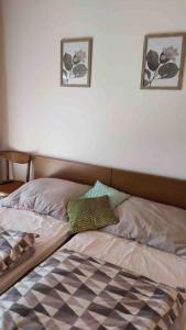 uma cama num quarto com duas fotografias na parede em Urokliwy drewniany dom z widokiem na Tatry em Tokarnia