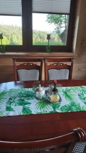 uma mesa com um conjunto de chá em cima em Urokliwy drewniany dom z widokiem na Tatry em Tokarnia