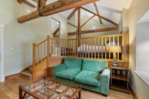 ein Wohnzimmer mit einem grünen Sofa und einem Bett in der Unterkunft Slebech Park Estate in Wiston