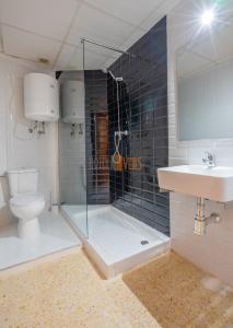 a bathroom with a shower and a toilet and a sink at Hotel Velis - Avenida I in Vélez-Málaga