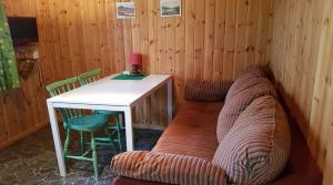 a couch in a room with a table and chairs at Överammers Cabins in Stugun