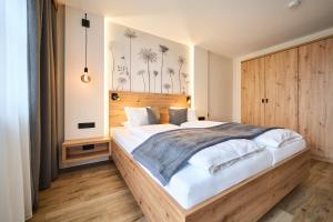 a bedroom with a large bed with a wooden headboard at Appartementhaus Silvia in Bad Füssing