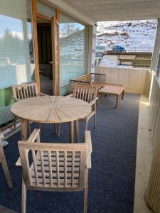 eine Veranda mit 2 Bänken, einem Tisch und Stühlen in der Unterkunft 2 Zimmer Wohnung in Lenzerheide