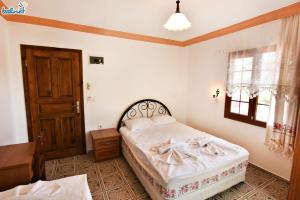 a bedroom with a bed and a window and a door at Melinda Pension & Restaurant in Mesudiye