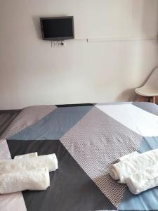 um quarto com duas toalhas numa cama com uma televisão em Aubagne 3 chambre au petit pin vert em Aubagne