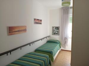 two beds sitting next to each other in a bedroom at Brezza Marina a 30 mt dalla spiaggia in Marina di Castagneto Carducci