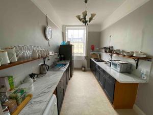 a large kitchen with a large counter in it at Great Pulteney St. Maisonette (parking) in Bath