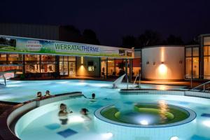 a group of people in a swimming pool at night at Ferienwohnung Walsetal in Wahlhausen