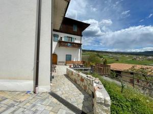 a large building with a balcony and a patio at Casa Streberi in Castelfondo