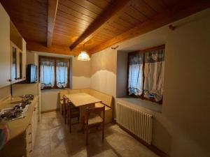 a kitchen with a table and a dining room at Casa Streberi in Castelfondo