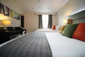 a hotel room with two beds and a desk at Silurian Hotel Newport in Newport