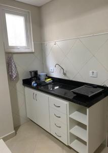 a small kitchen with a sink and a window at POSIT APARTAMENTOS in Curitiba