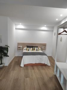 1 dormitorio con 1 cama en una habitación blanca en Apartamentos turísticos Demar en O Grove