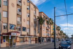 a large building on a city street with palm trees at Hotel Velis in Vélez-Málaga
