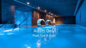 直布罗陀E1 Suites & Spa aparthotel style - Gym & Spa的室内的蓝色海水游泳池