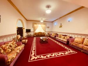 un grand salon avec des canapés et un tapis rouge dans l'établissement Holiday Home Rent villa, à Charjah
