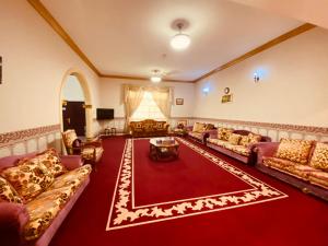 a large living room with couches and a red rug at Private Cottage in Sharjah