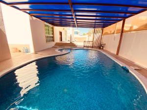 Holiday Home Rent villa في الشارقة: مسبح في بيت بسقف ازرق