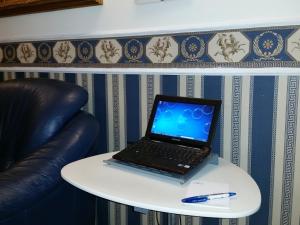 a laptop computer sitting on a table next to a chair at Hotel Teti in Rome