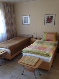 a bedroom with two twin beds and a table at Guesthouse AirMinis in Düsseldorf +10 photos