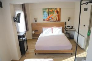 a bedroom with a bed and a desk and a painting at Şenyıldız Hotel in İzmir