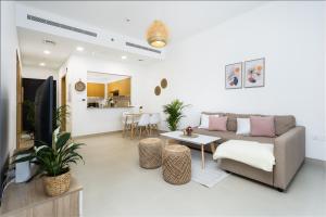 een woonkamer met een bank en een tafel bij Waves Holiday Home - Chic Apartment With Dubai Skyline Views in Dubai
