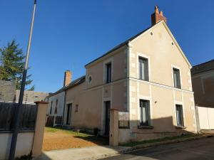 an old white building on the side of a street at Gîte une histoire de village in Genneteil