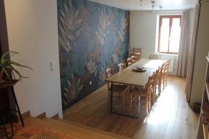 a dining room with a long table and chairs at Gîte une histoire de village in Genneteil