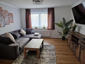 uma sala de estar com um sofá e uma mesa de centro em Ferienwohnungen Waldina em Siegen