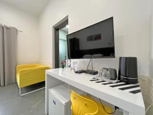 a room with a white desk with a tv on the wall at Apollo Rooms by Albert's Apartment in Larnaka