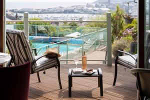 a balcony with two chairs and a table with a wine glass at Hotel Penzance in Penzance