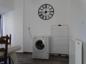 a room with a washing machine and a clock on the wall at Agréable maison proche de la côte de granit rose in Lannion