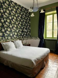 una camera con un letto con una parete floreale di Hôtel Restaurant Chez Gervais a Quingey