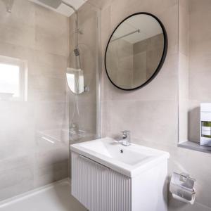 Baño blanco con lavabo y espejo en The Bracken's by Ritual Stays en Hemel Hempstead