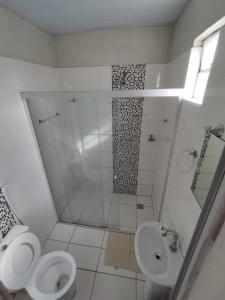 a bathroom with a shower and a toilet and a sink at Hotel Resende in Imperatriz