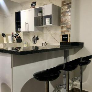 una cocina con taburetes negros en un mostrador en Aparta_Suite_Sogamoso, en Sogamoso