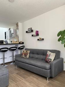 Una sala de estar con un sofá y un mostrador. en Aparta_Suite_Sogamoso, en Sogamoso