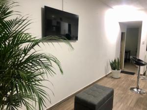 Una sala de estar con un sofá y un televisor en una pared. en Aparta_Suite_Sogamoso, en Sogamoso 5 fotos más