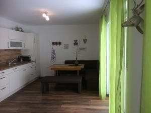 een woonkamer met een tafel en een groen gordijn bij Appartementhaus Angelika in Nittenau
