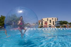 a woman is in the water with a frisbee at Grand Hotel Primus - Terme Ptuj - Sava Hotels & Resorts in Ptuj
