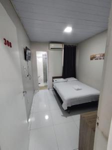 a small room with a bed and a bathroom at Hotel Resende in Imperatriz