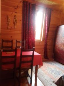 ein Esszimmer mit einem Tisch und einem Fenster in der Unterkunft Gîte l'appel de la Forêt in Betplan