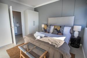 a bedroom with a large bed with a couch at The Space To Be in Durban