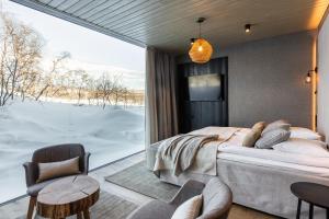 a bedroom with a bed and a large window at Santa's Hotel Rakka in Kilpisjärvi
