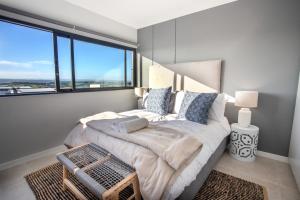 a bedroom with a bed with a large window at The Space To Be in Durban