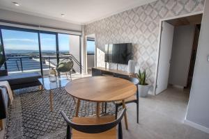 ein Wohnzimmer mit einem Tisch und einem TV in der Unterkunft The Space To Be in Durban